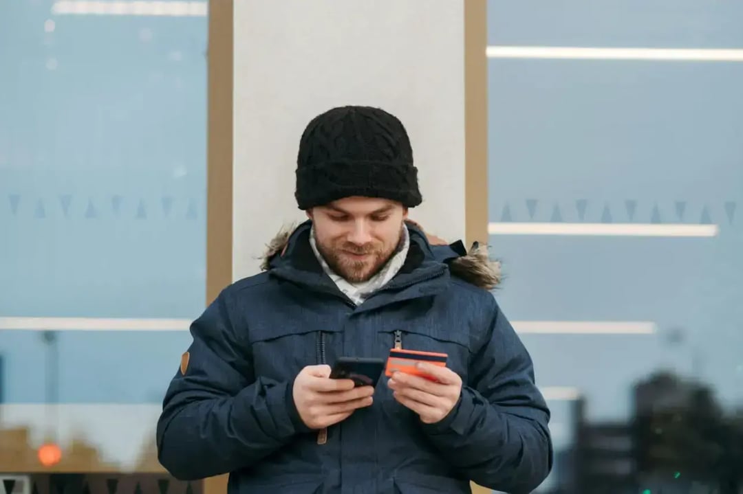 man-entering-details-of-credit-card-on-smartphone-on-street