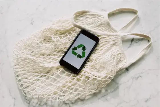 mobile-phone-with-green-recycling-sign-and-mesh-bag