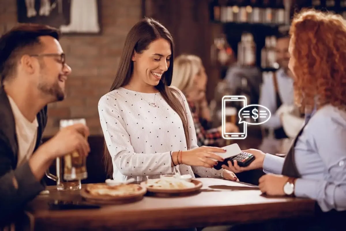 young-happy-woman-using-smart-phone-while-paying-bill-waitress-bar